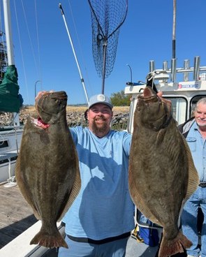 Angler holding two California halibut