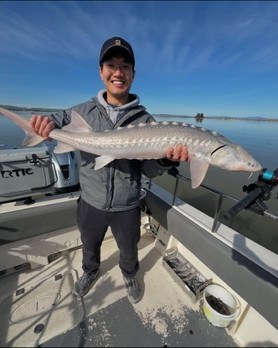Angler holding a sturgeon catch on the boat